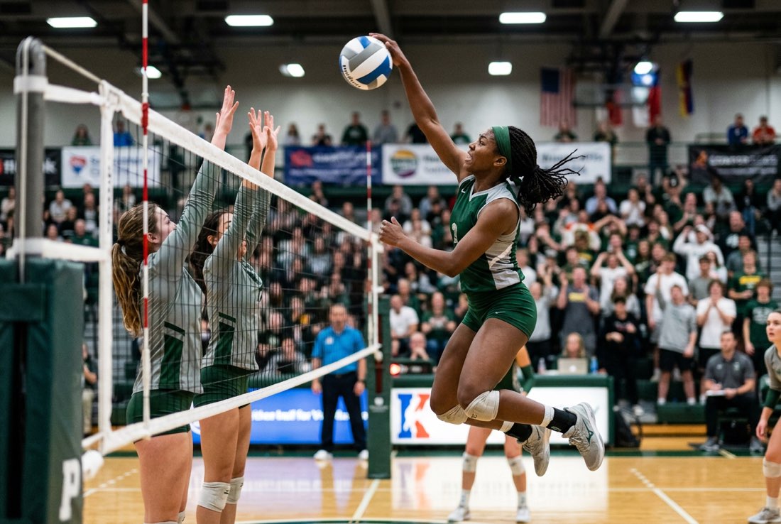 A Hawks volleyball player leaping to spike the ball